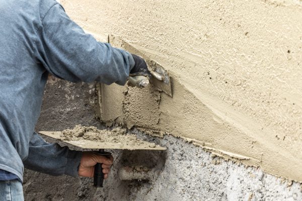 Tile Worker Applying Cement with Trowel at Pool Construction Site.